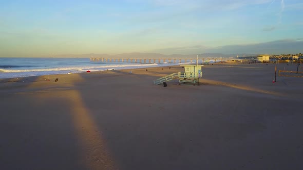 Aerial drone uav view of a lifeguard tower, pier, beach and ocean.