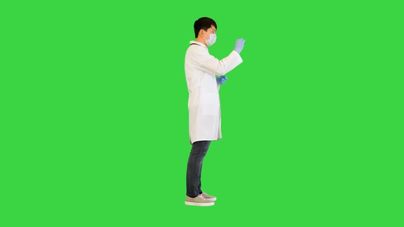 Young Asian Doctor Comparing Two Ampules with Red and Blue Solution on a Green Screen Chroma Key