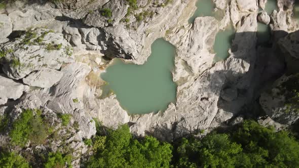 rotary motion drone headshot of Albanian canyon "Syri i ciklopit". Albanian nature stock videos.