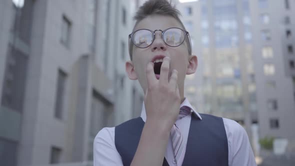 Handsome Well-dressed Boy Standing on the Street Yawning