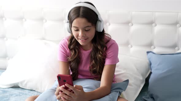 Happy Teen Girl Speaking on Cellphone Online in Headphones Wireless Device