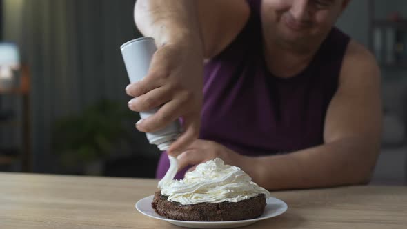 Fat Male Decorating Cake with Whipped Cream and Putting Cherry on The Top