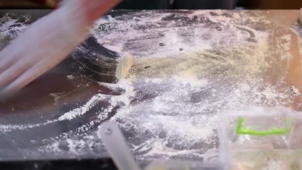 Cook is Cleaning Kitchen Desk From Dough Remains