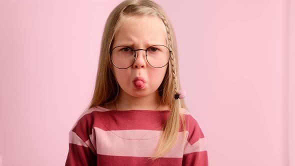 Little girl child angry and upset, frowning her brow and showing tongue.