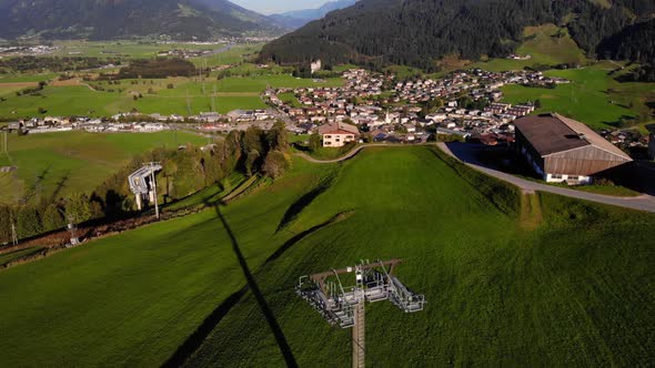 Ski lift Tower Of Maiskogelbahn At The Rural Town Of Kaprun In Austria. descending drone shot