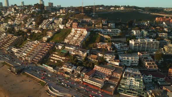 Aerial view across Reñaca Chile resort buildings on golden sunrise beach coastline