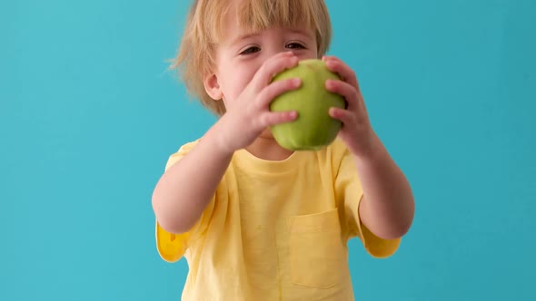 Small Boy Holds a Big Green Apple