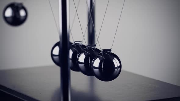 The balls of a Newtons Cradle colliding in slow motion