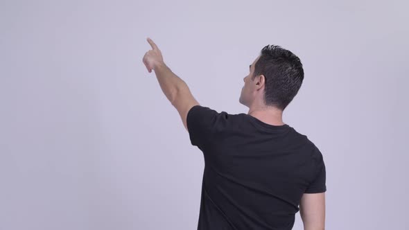 Rear View of Man Pointing Finger Against White Background