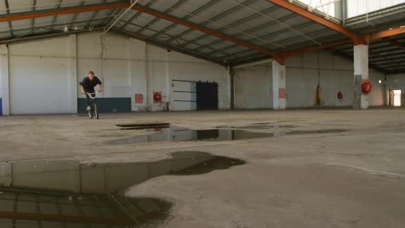 BMX rider in an empty warehouse