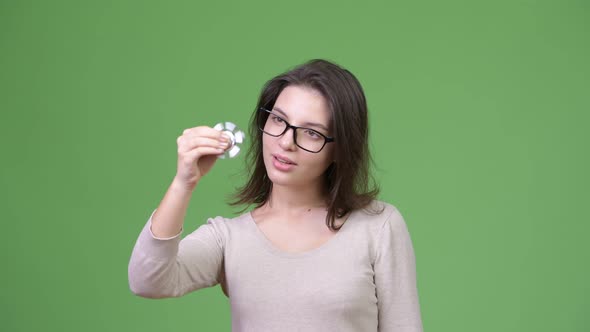 Young Beautiful Woman Playing with Fidget Spinner and Focusing