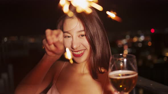 Young asian woman with sparklers is dancing and celebrating a new year. Fireworks,