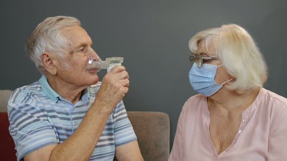 Senior Couple Grandfather and Grandmother Monitoring Oxygen Saturation. Breathing Device To Breathe