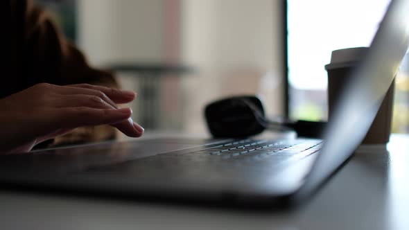 Closeup a woman working and touching on laptop computer touchpad on the table