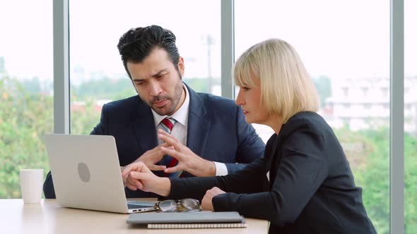 Two Business People Talk Project Strategy at Office