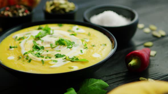 Pumpkin Soup in Bowl Sprinkled with Herbs