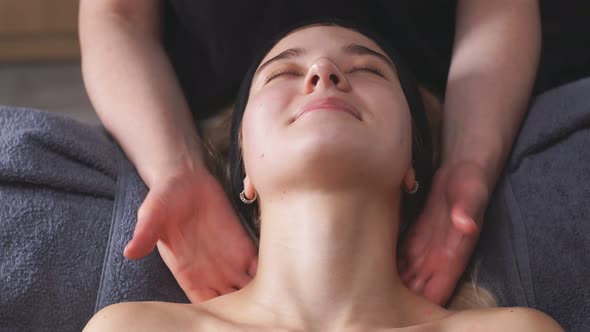 Young Woman in a Chic Beauty Salon Gets a Facial Massage and Beauty Treatments for Skin Care