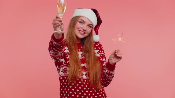 Lovely Girl in Christmas Santa Sweater Dancing with Bengal Sparklers Fireworks and Champagne Glass