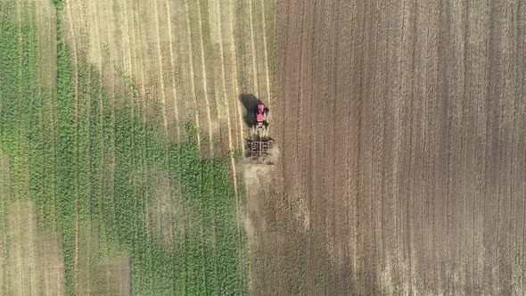 Agricultural Red Big Tractor in the Field Plowing