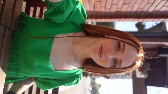 Vertical Portrait of Attractive Young Woman Talking Video Call Looking at Camera Sitting at Table in