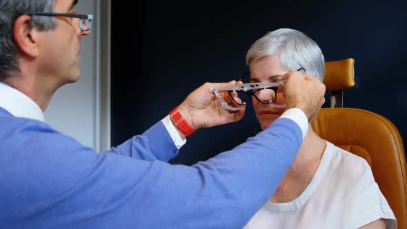 Optometrist examining patient eyes with eye test equipment 4k