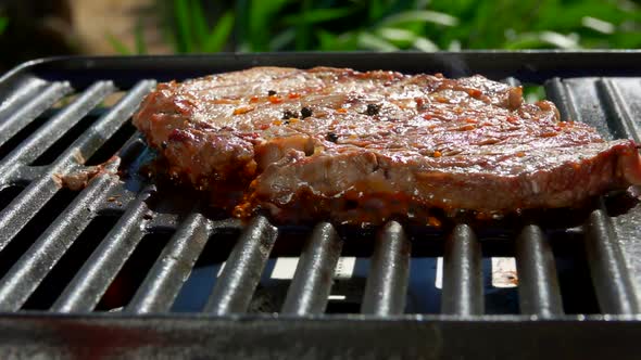 Smoke Rises Above the Steak on a Hot Grill