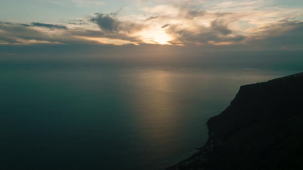 Silhouette of travelers at Raposeira viewpoint enjoying Atlantic sunset; aerial