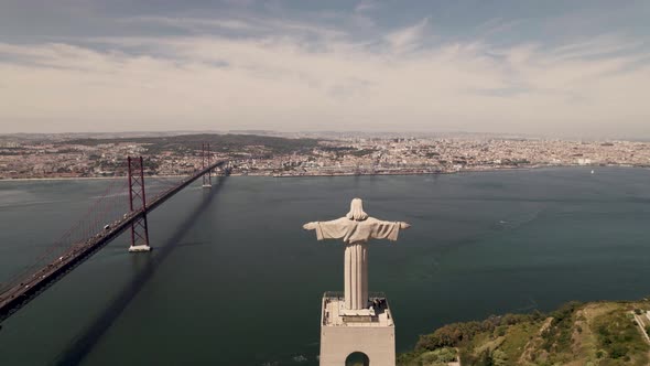 Aerial fly over Cristo rei, Christ the King Sanctuary, view Lisbon riverside cityscape.