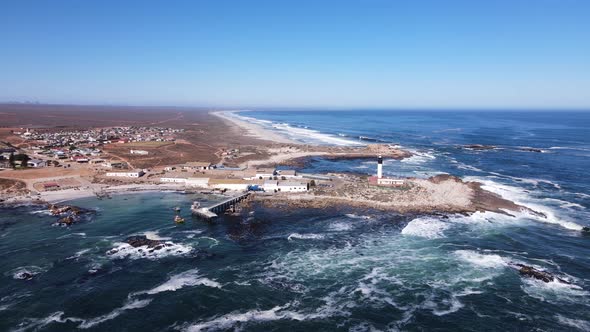 Drone push-in descent towards lighthouse and old crayfish factory; Doringbaai
