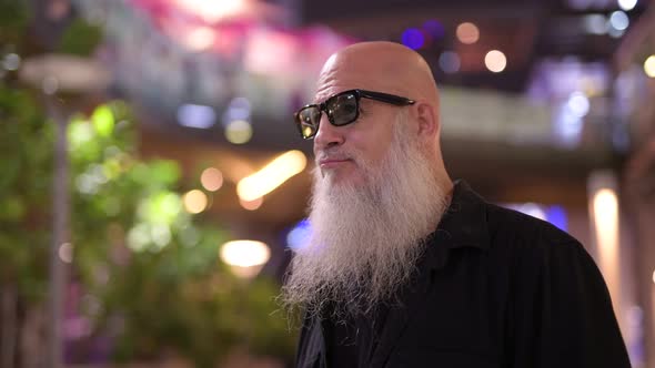 Mature Bald Bearded Tourist Man Waiting Against View of the City at Night