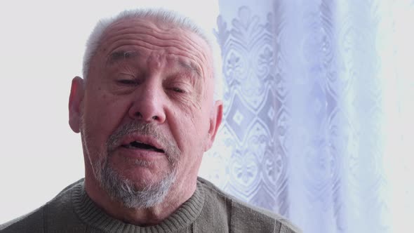 Elderly Man Looking at Camera with Serious Facial Expression