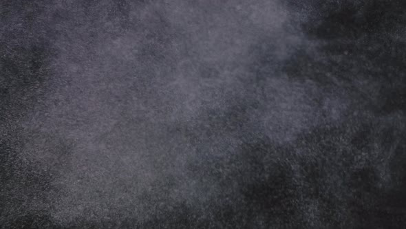 Floating Dust on a Black Smoky Background. Cinematic Dust for Film Editing. Small Round Particles