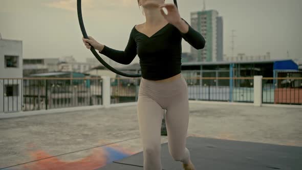 Woman in sportswear stretching and warm up before doing yoga on the rooftop in the evening.