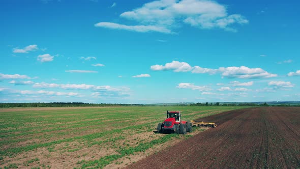 Agricultural Tractor Plows Ground for Seeds Planting.