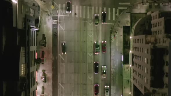 AERIAL: Overhead View of Cinematic Street at Night in Los Angeles with Car Traffic Lights 