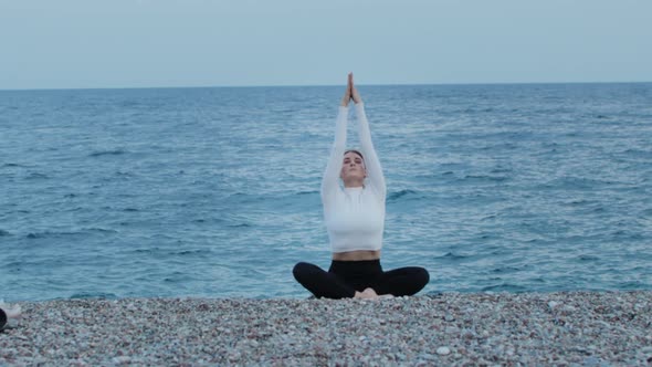 Fitness Outdoors  a Woman Doing Yoga By the Blue Sea