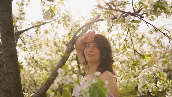 Attractive Woman Near Flowering Tree in Spring Park