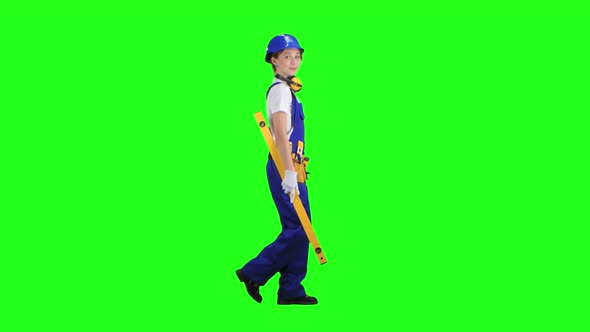 Girl Is Wearing a Yellow Building Level. Green Screen. Side View