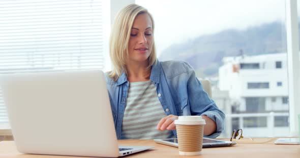 Businesswoman using digital tablet at her desk