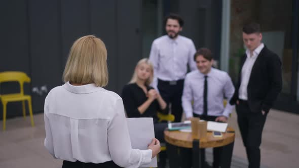 Back View Woman Presenting Business Idea on Office Terrace with Blurred Employees Clapping in Slow