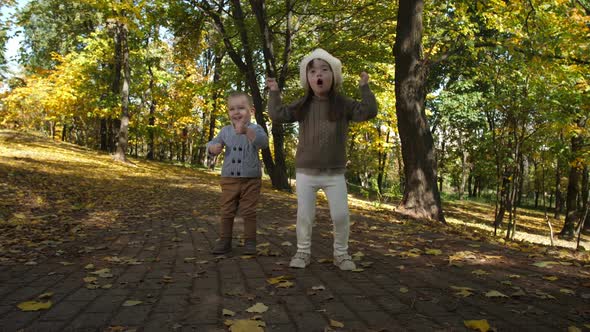 Joyful Little Siblings Dancing Funny on Park Alley