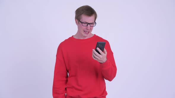 Stressed Young Man Using Phone and Getting Bad News