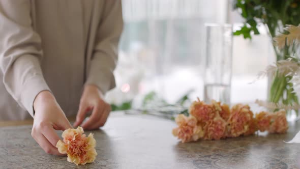 Woman Arranging Flowers on Table