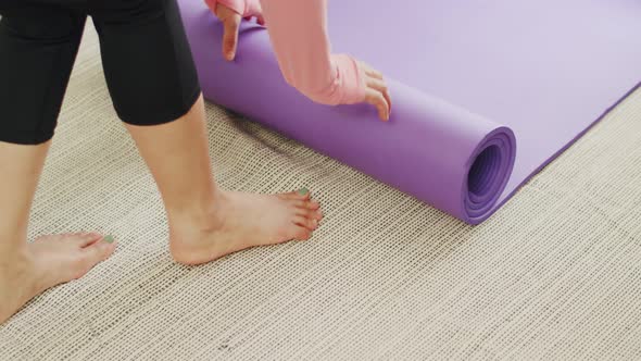 Close up hands of caucasian woman unrolling exercise mats.