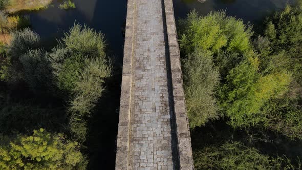 Roman bridge on Seda river at Vila Formosa In Portugal. Aerial forward tilt up reveal