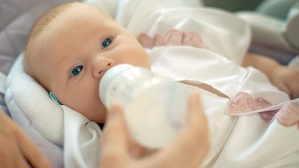 Mother Feeding Her Newborn Baby From Bottle