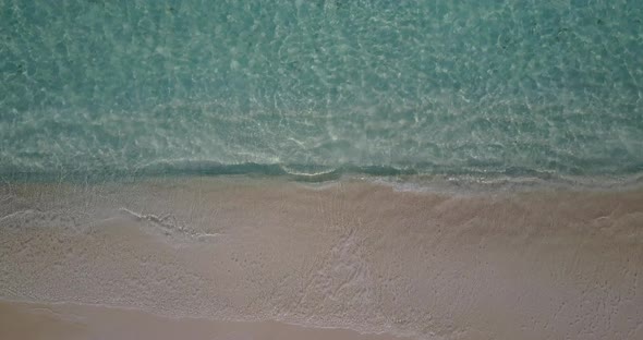 Wide angle drone clean view of a white sand paradise beach and blue sea background in colourful 4K