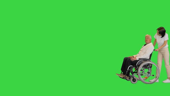 Disabled Senior Man and Assistant Walking By on a Green Screen Chroma Key