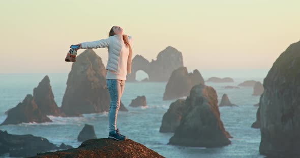 Free Happy Beautiful Woman in White Jacket Looking Up Around with Raised Arms