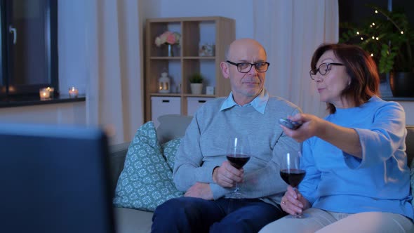 Happy Senior Couple Drink Red Wine and Watch Tv